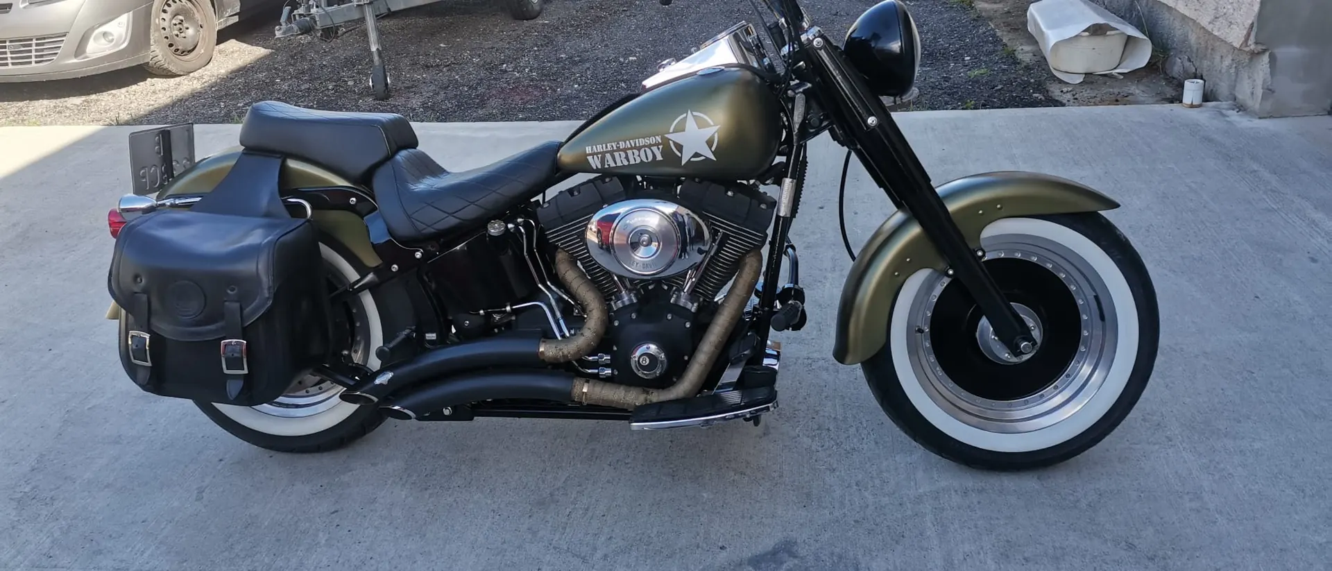 Harley-Davidson Softail v maskáčovom laku pred dielňou